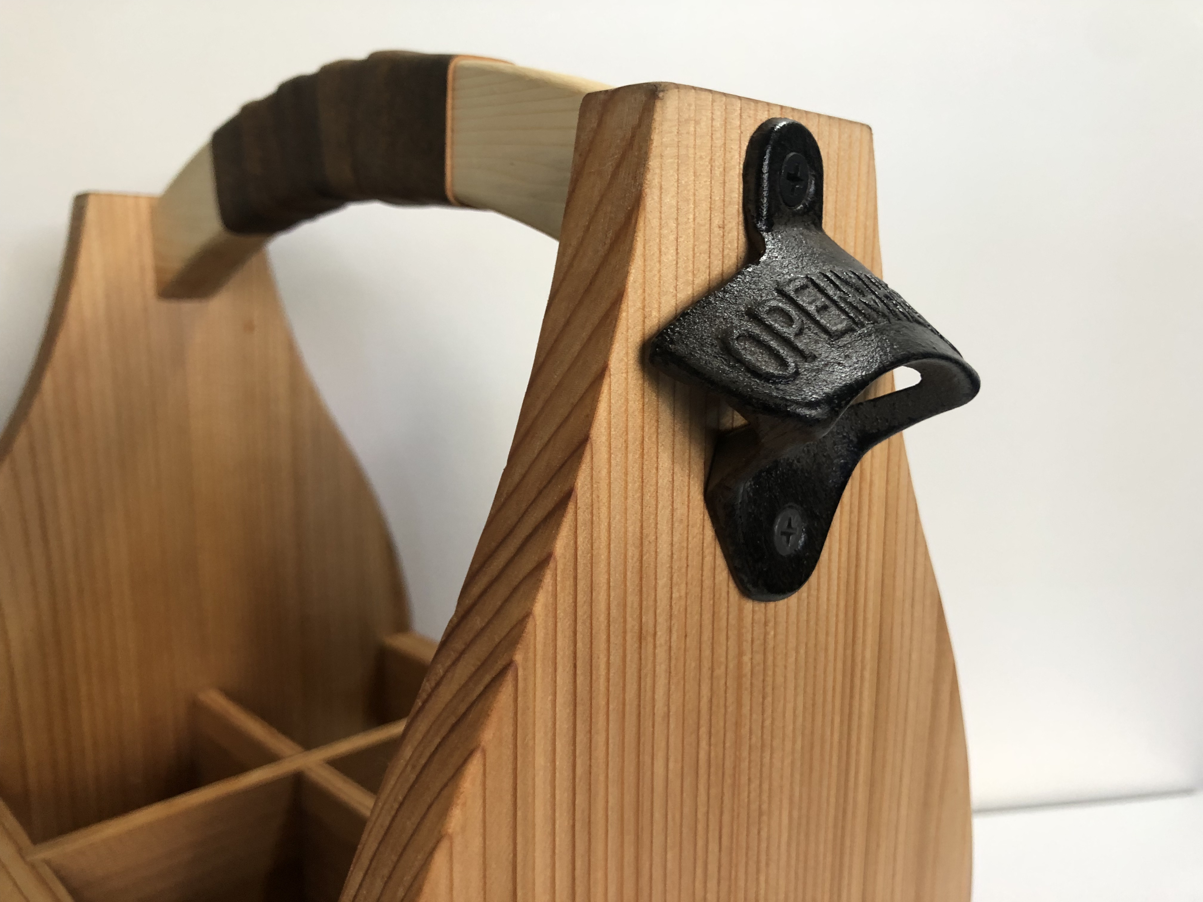 Wooden beer caddy with custom engraving, leather handle and bottle opener.